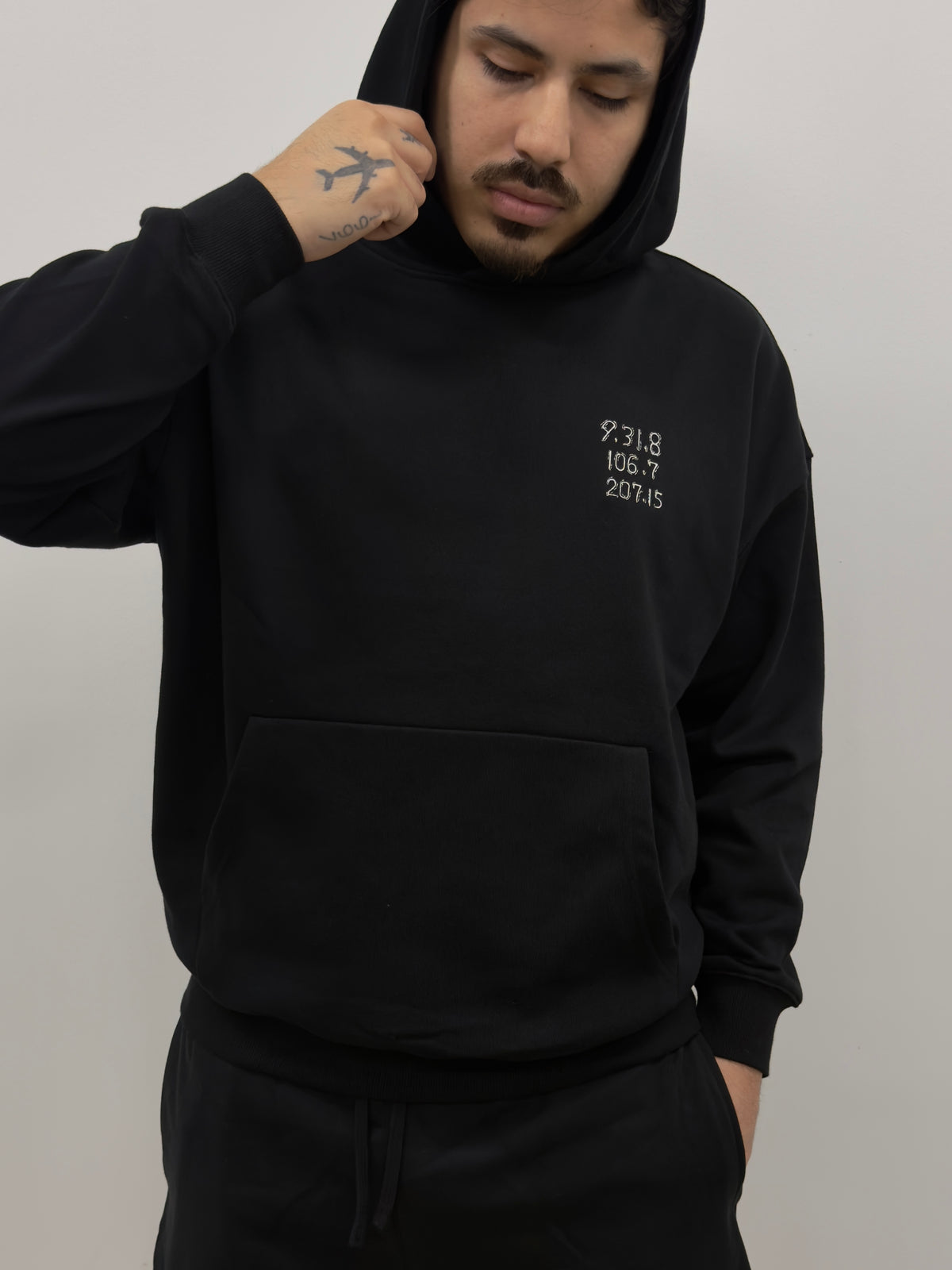 Model wearing The Last Message black hoodie with Jiraiya's coded message embroidered on the chest