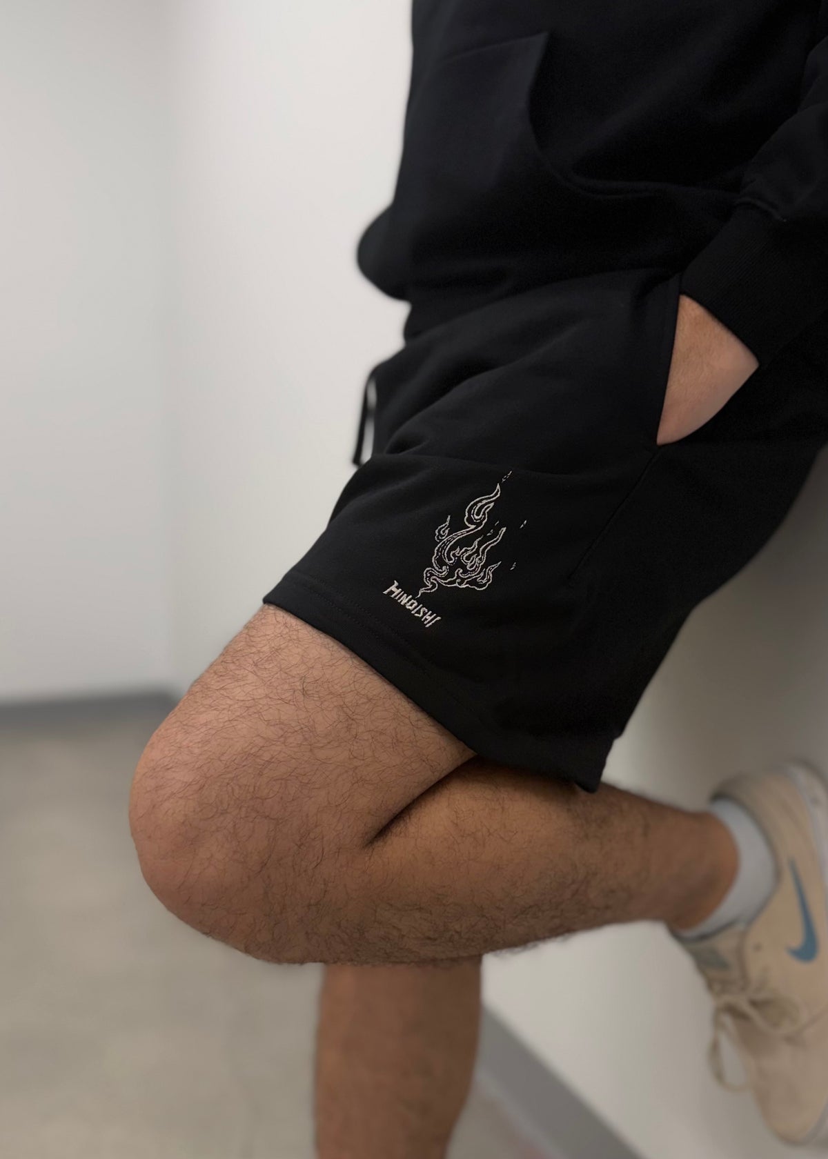 Model wearing the Will of Fire black shorts with Naruto-inspired embroidered flame, anime streetwear