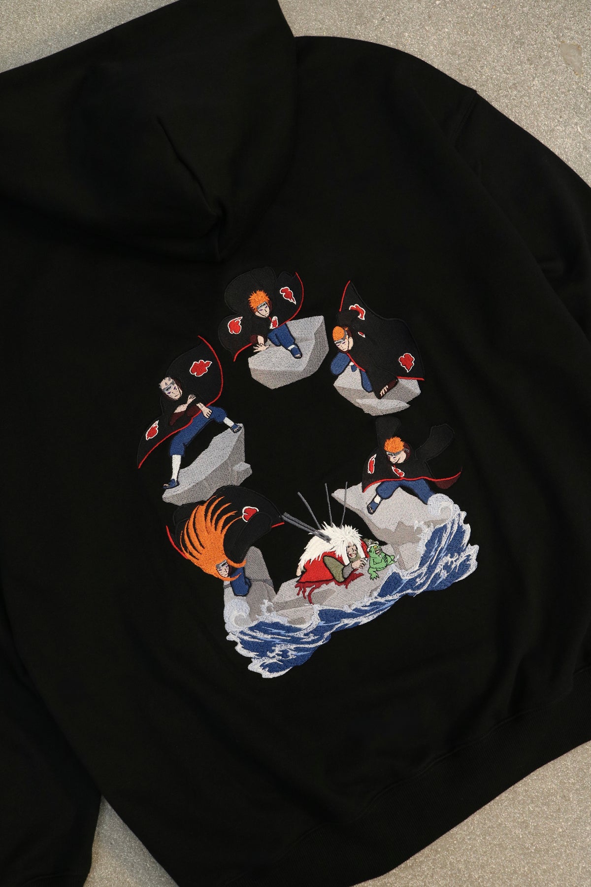 Close-up of back embroidery: the Six Paths of Pain surrounding a fallen Jiraiya with a toad, Naruto anime streetwear