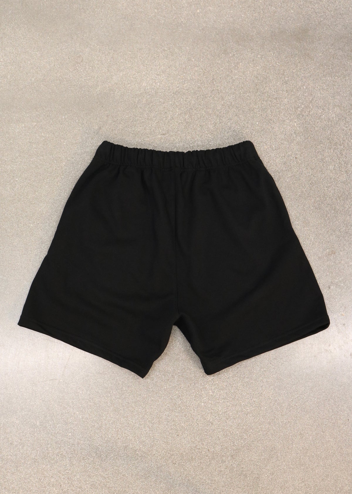 Will of Fire black shorts laid flat, back view with elastic waistband