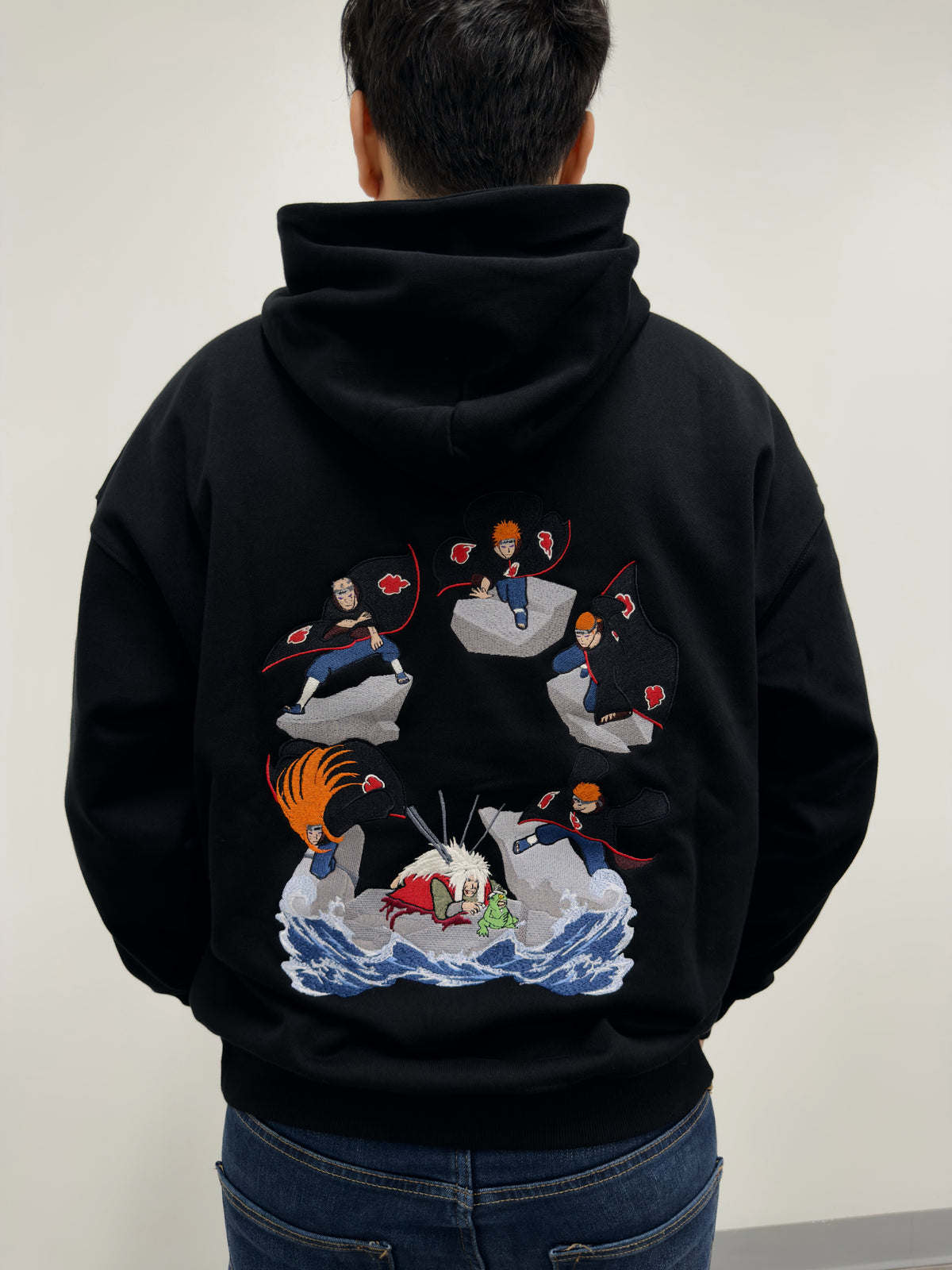 Model wearing The Last Message black hoodie with embroidered Jiraiya vs Pain battle scene on the back