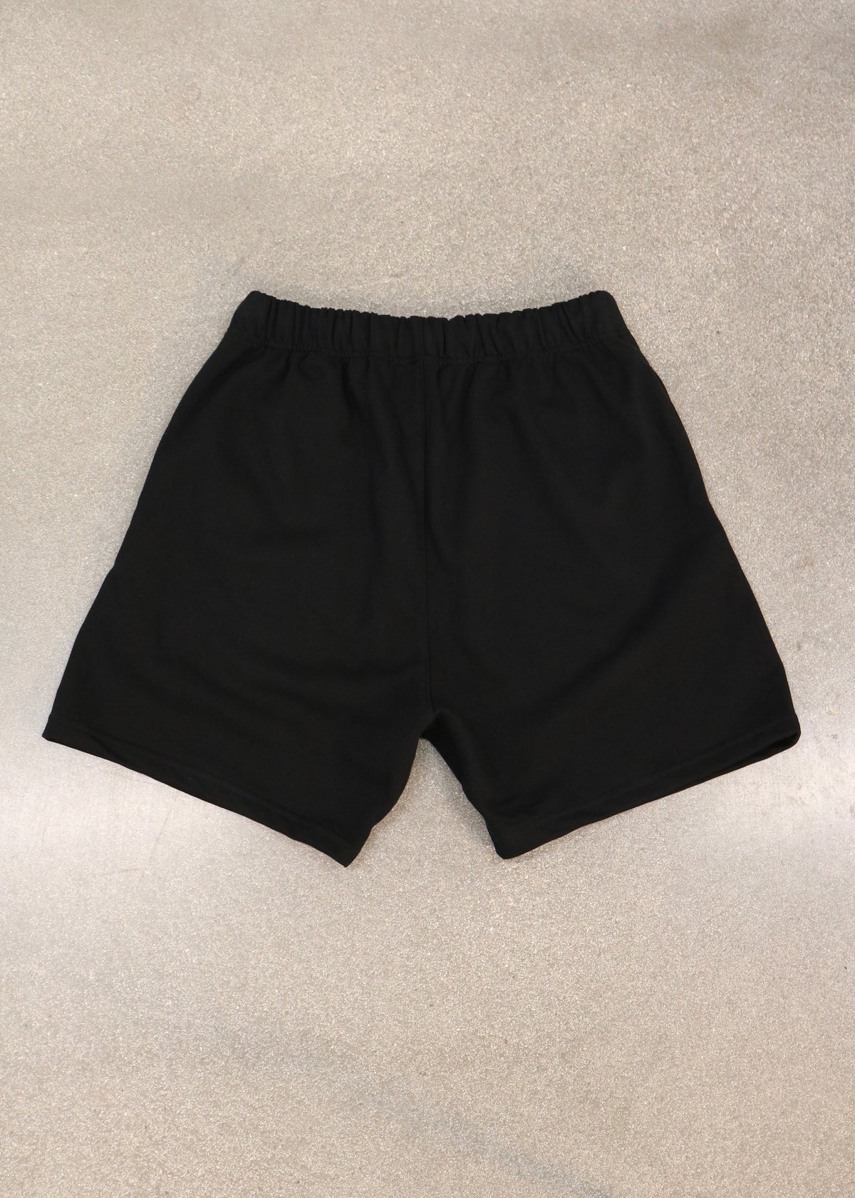 Pain-Amegakure Deity black shorts laid flat, back view with elastic waistband
