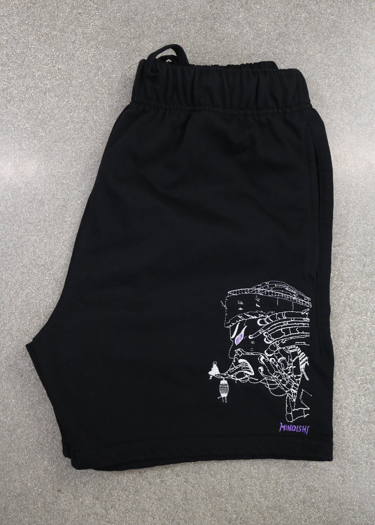 Folded Pain-Amegakure Deity shorts showing the embroidered Pain of Amegakure and purple HINOISHI logo