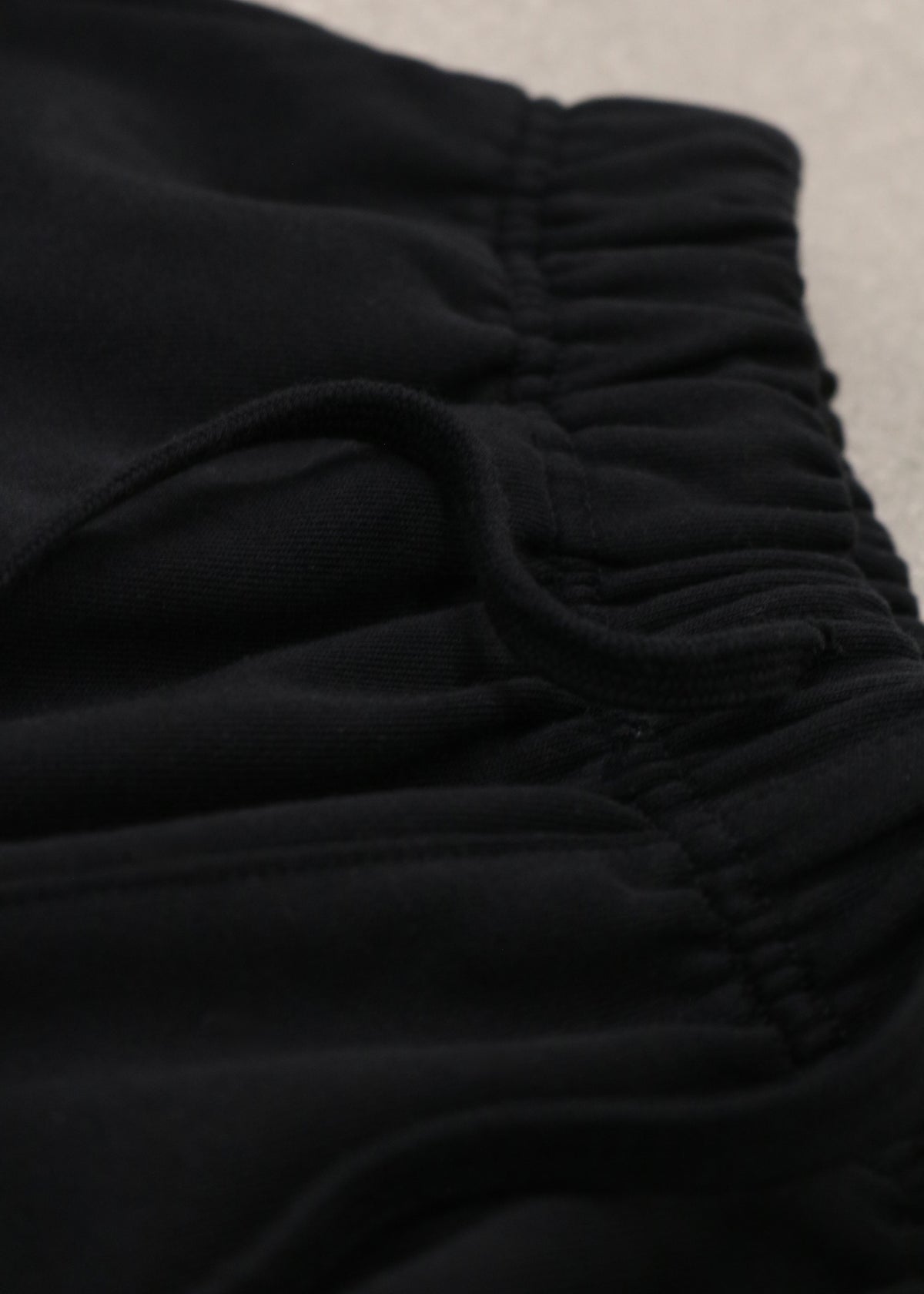 Close-up of the elastic waistband and drawstring of the Pain-Amegakure Deity black shorts