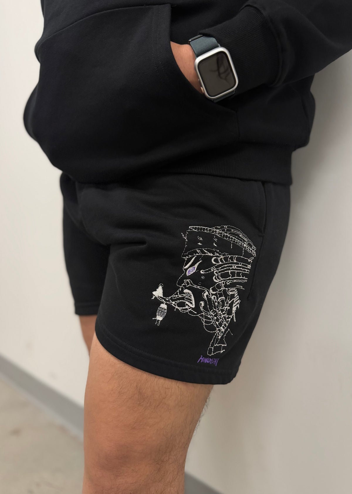 Side view of model wearing the Pain-Amegakure Deity shorts with Pain line-art embroidery