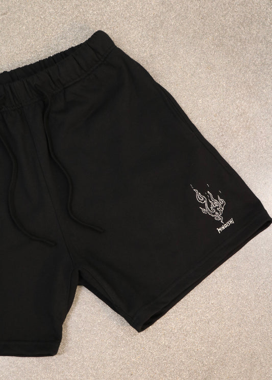 Close-up of the Will of Fire black shorts with embroidered flame and HINOISHI logo on the leg