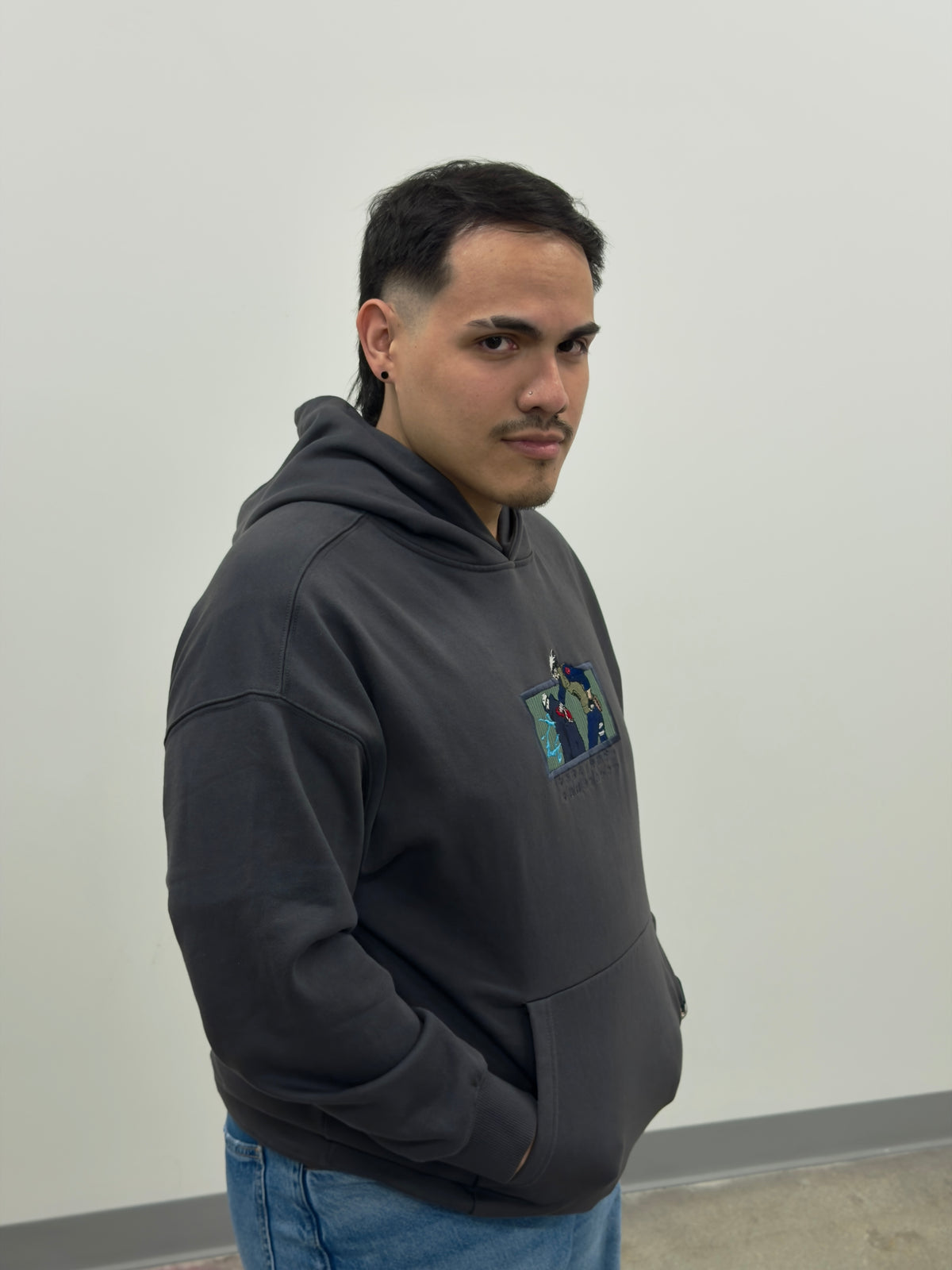 Side view of model wearing the Copy Ninja Killshot hoodie with embroidered Kakashi and Kakuzu patch