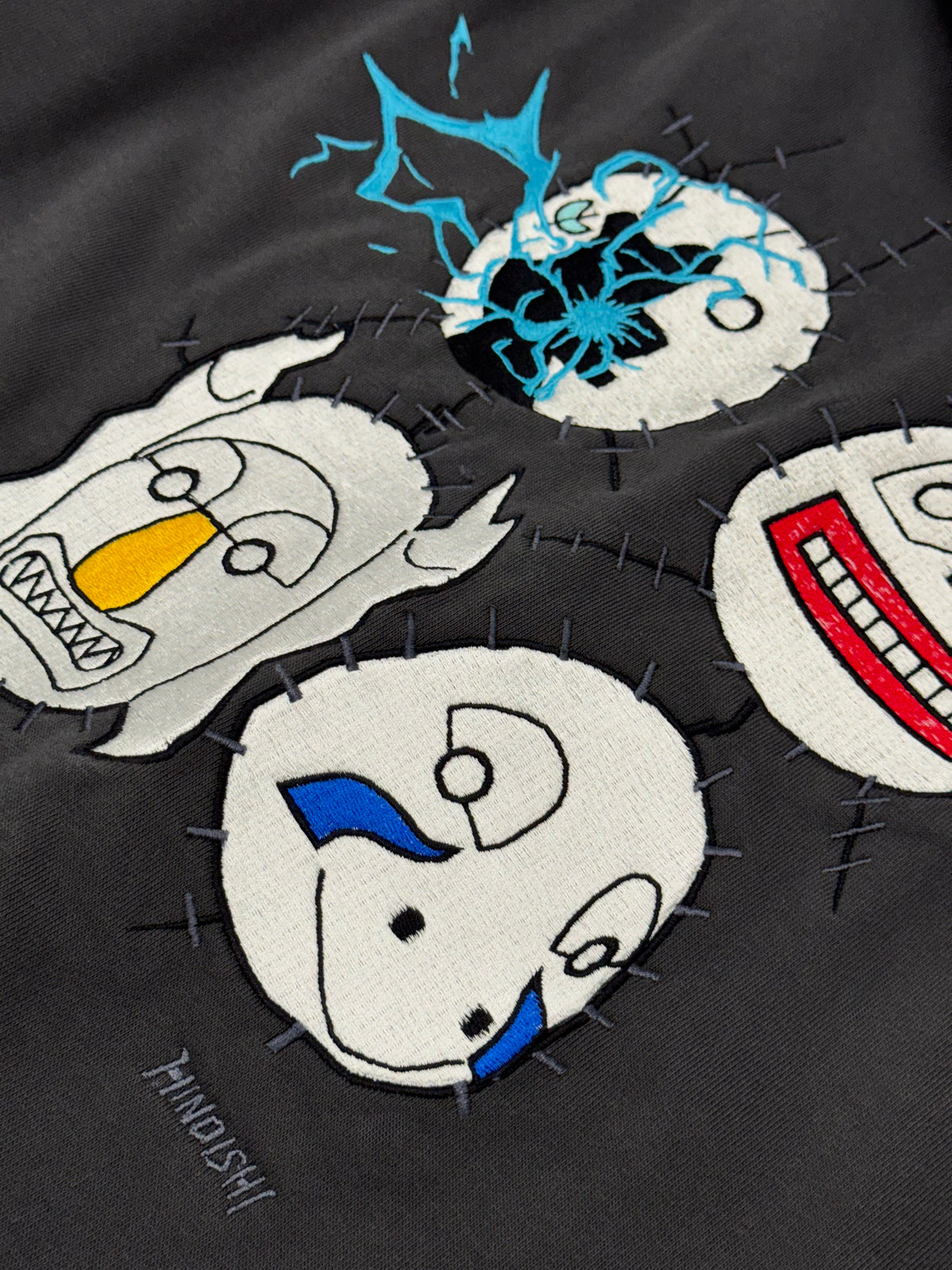 Close-up of back embroidery: Kakuzu's stitched masks with Kakashi's Raikiri lightning, Naruto anime streetwear