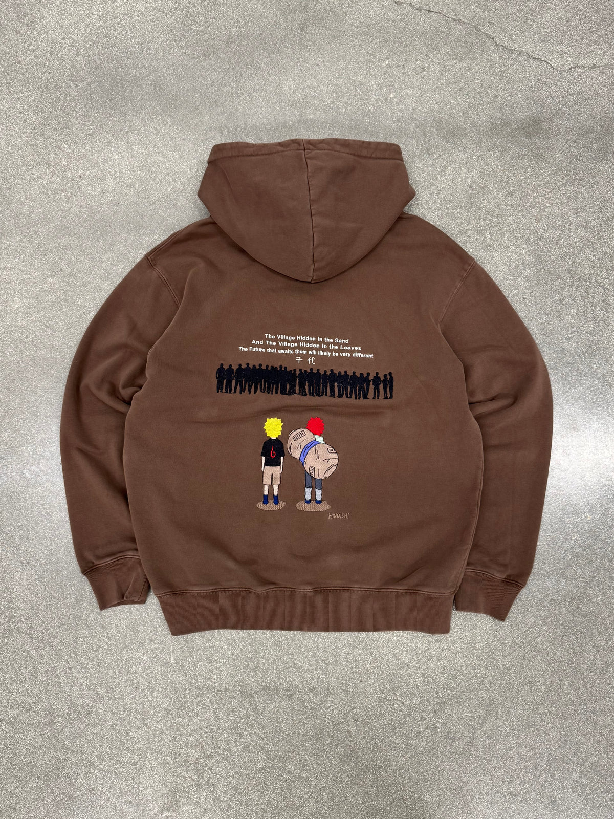 Two Tails Fates brown hoodie laid flat, back view with full embroidered Naruto and Gaara scene