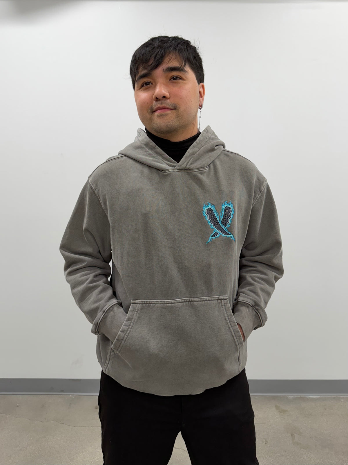 Model wearing the Legacy of the Flame hoodie with Asuma's crossed chakra blades embroidered on the chest