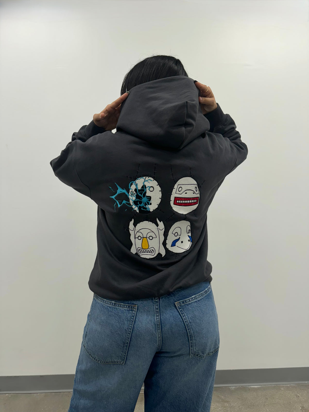 Back of the Copy Ninja Killshot hoodie: Kakuzu's four masks embroidered, one struck by Kakashi's Lightning Blade